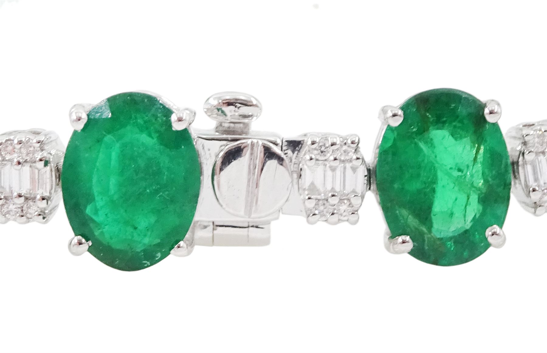 18ct white gold emerald and diamond bracelet, fifteen oval cut emeralds, spaced by clusters of baguette cut and round brilliant cut diamonds, stamped, total emerald weight approx 15.15 carat, total diamond weight approx 1.85 carat