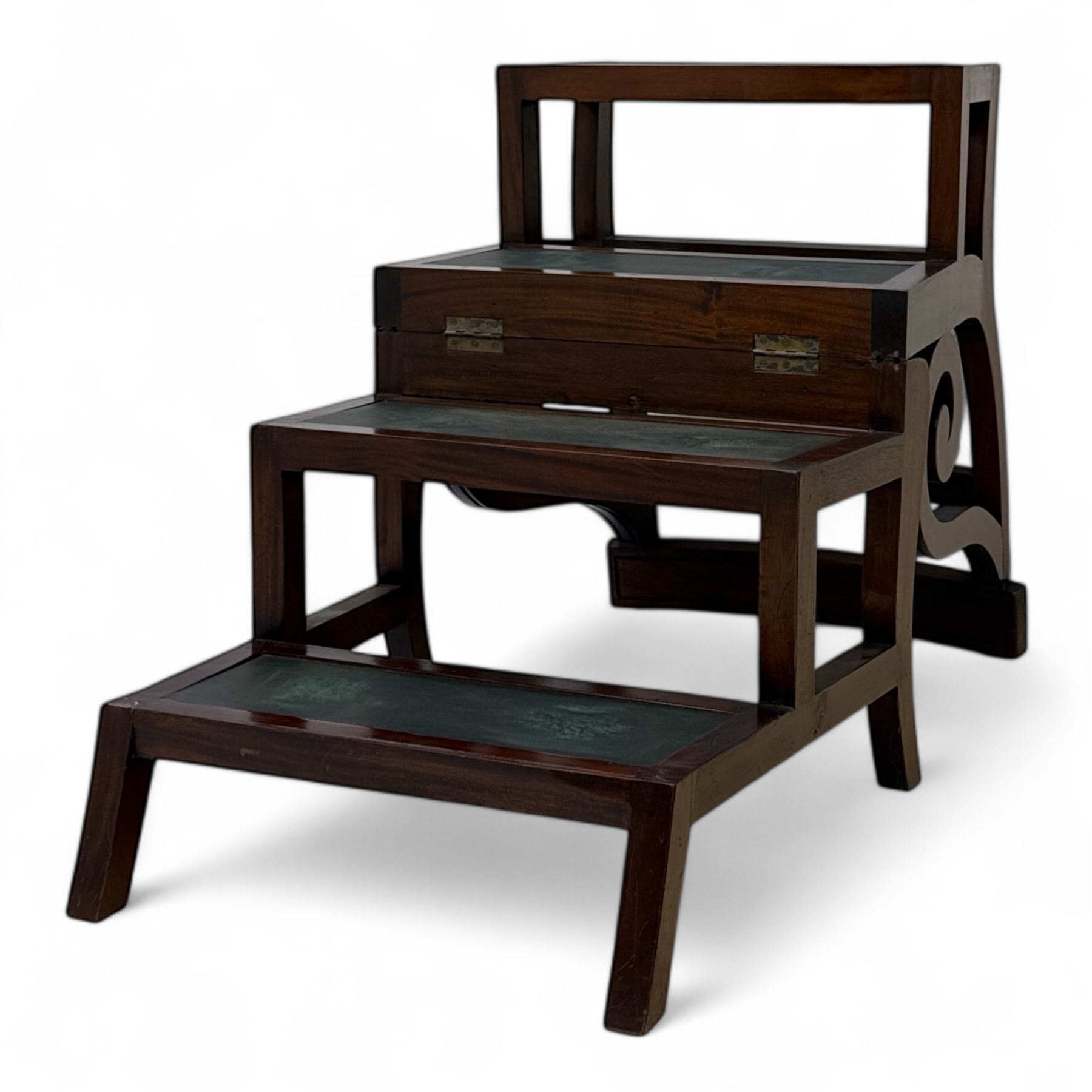 In the manner of Morgan & Sanders - early 20th century Regency design mahogany metaphoric library chair and steps, rectangular panelled top-rail with applied roundels with scrolling arms and upholstered seat and cushion, hinged and folding design transforming into four carpeted steps

Reference: The present lot is based on a design for a metamorphic library chair published by Morgan & Saunders circa 1810, P.Agius, Ackermann's Regency Furniture & Interiors, plate 29, page 60