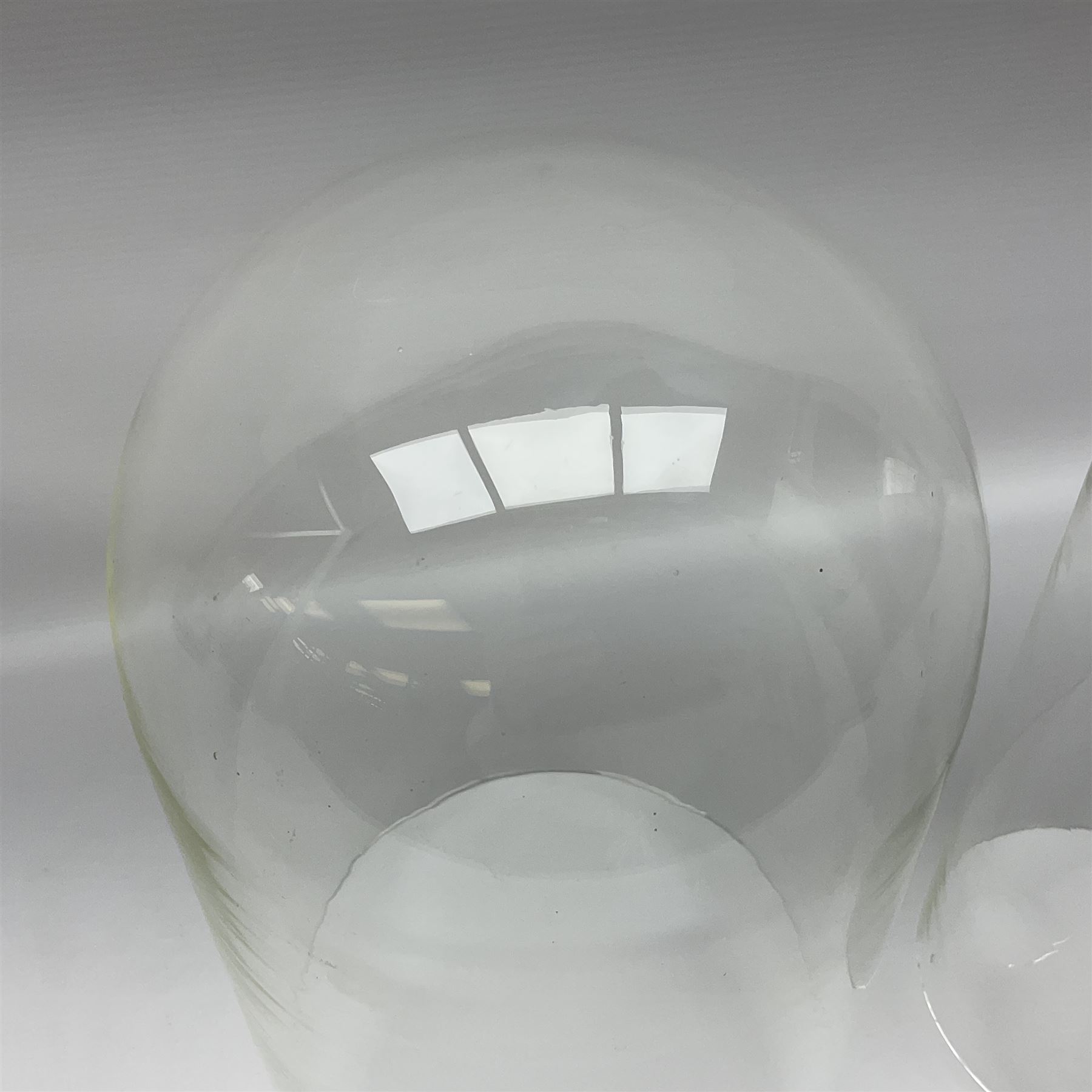 Tabletop glass display cabinet, with hinged door, together with two glass domes