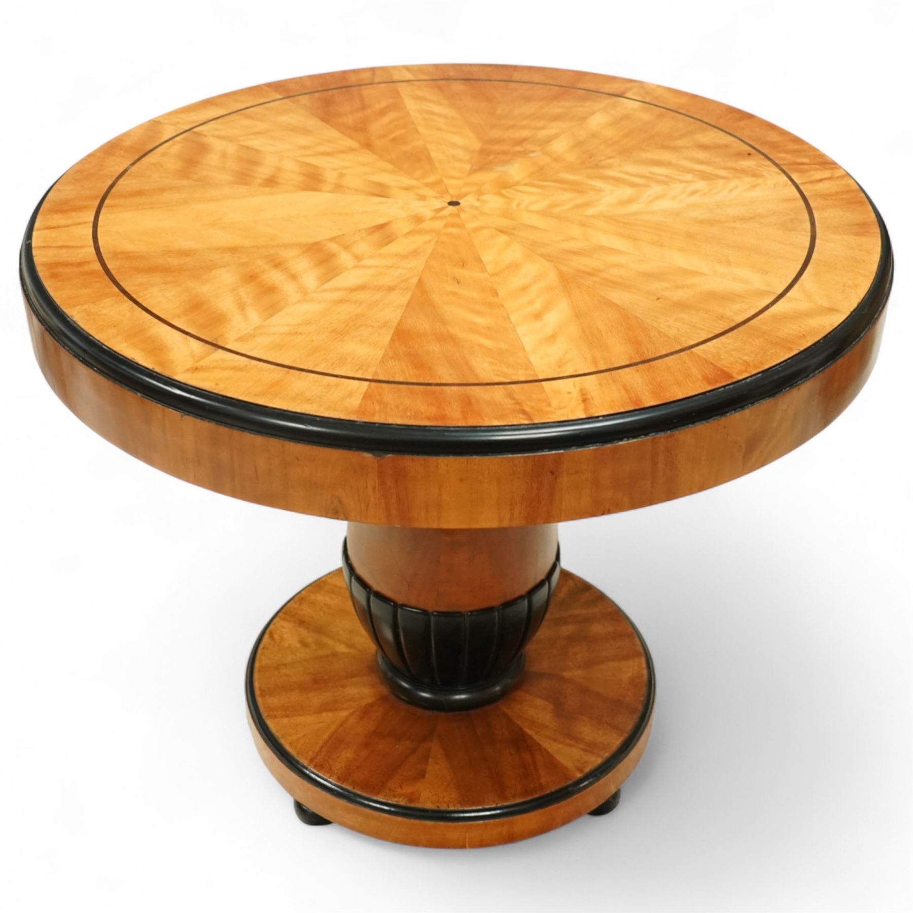 Mid-20th-century Biedermeier-style ebonized and satinwood pedestal table, quarter-veneered circular top with ebonized edge above a tapered baluster quarter-lobed column, raised on a circular plinth base, D87xH70cm, together with two matching upholstered spoon back chairs W45xD47xH87cm
