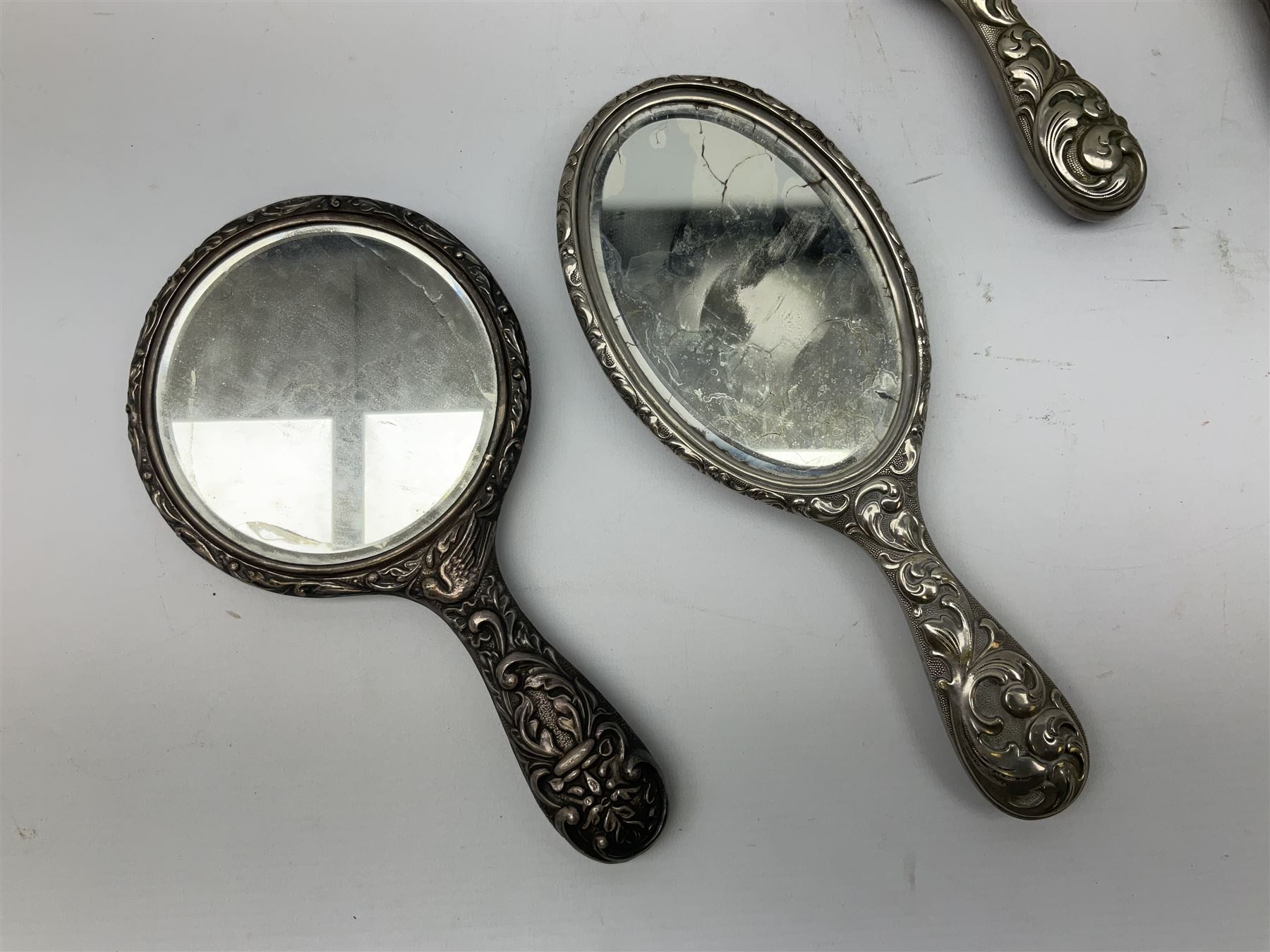 Glass dressing table tray, scent bottles and lidded bowl, metal mounted foliate design hair brushes and handheld mirrors etc