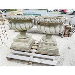 Pair of large weathered Country House Haddonstone garden urns, acanthus carved rim above gadrooned bowl, beaded detailing to the neck, raised on stepped double plinth base
