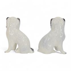 Pair of 19th century slip moulded pottery spaniels, circa 1840-1850, possibly Scottish, modelled with free standing forelegs and moulded fur with dark brown detailing and yellow glazed collars and padlocks upon a white ground, H17.5cm