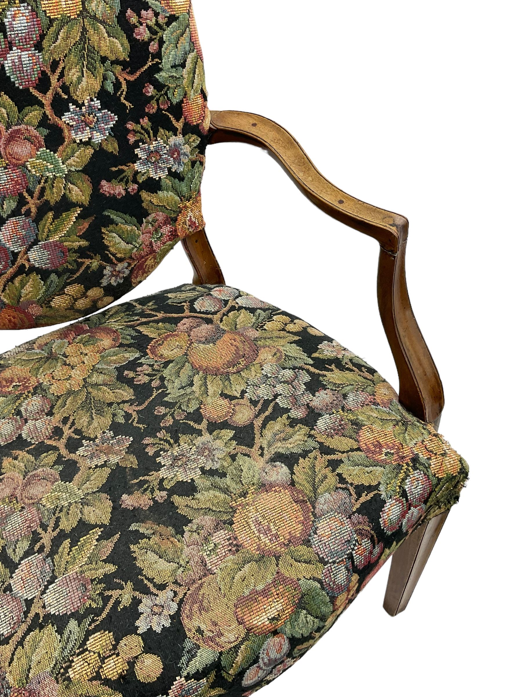 Pair of George III mahogany framed open armchairs, oval back and serpentine seat upholstered in fruit and foliage patterned fabric, shaped and moulded arms and arm supports, on square tapering moulded front supports 