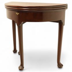 20th-century Georgian Revival style double fold-over card table, the first hinged circular top with polished mahogany surface above a second hinged circular top revealing a green baize playing surface with four counter-wells, underneath with a recessed compartment with and  chip and dice wells, the apron with fitted lock and key, raised on slender straight legs with pad feet 