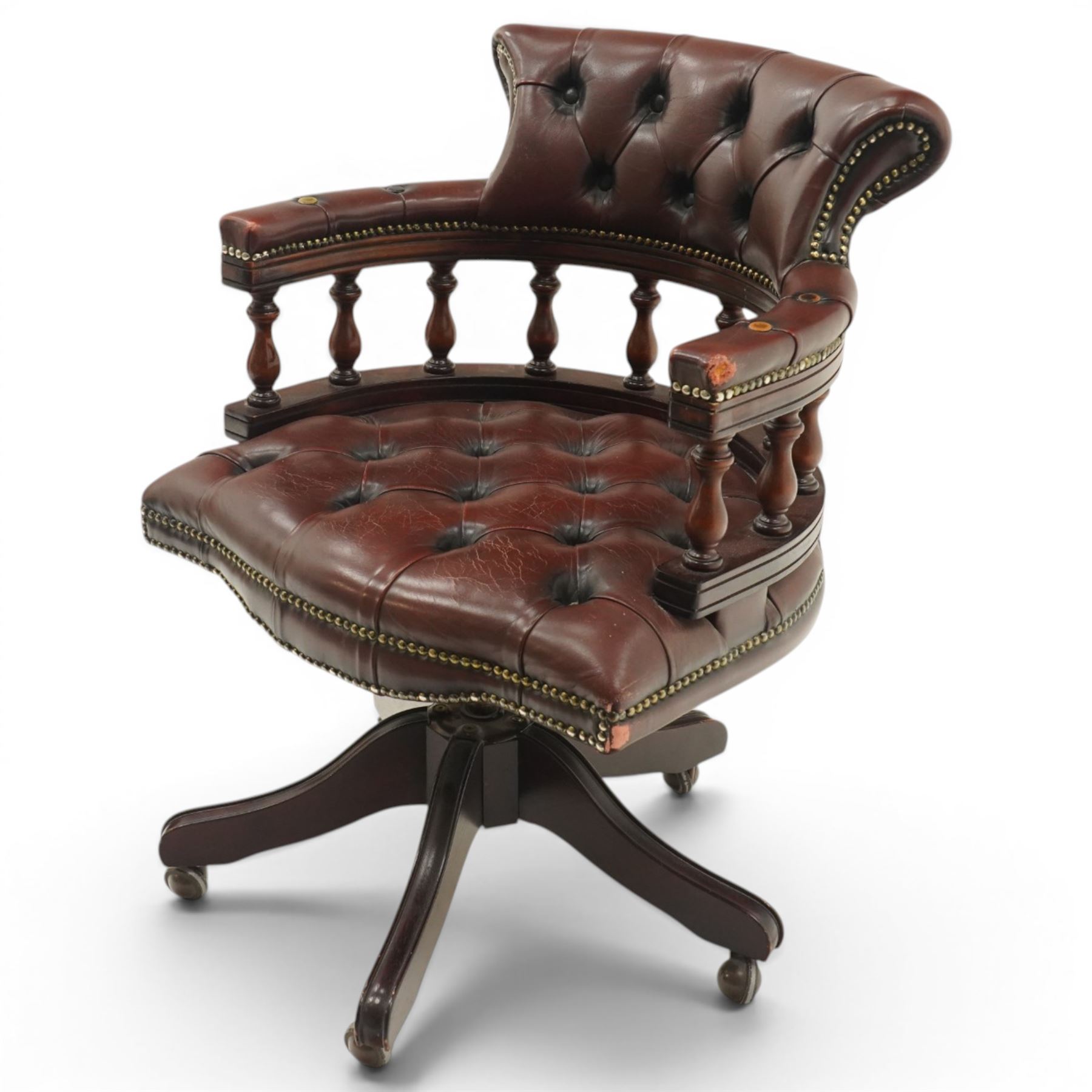 Georgian design captains swivel desk chair, rolled cresting rail over open spindle back on tripod base, upholstered in buttoned oxblood leather