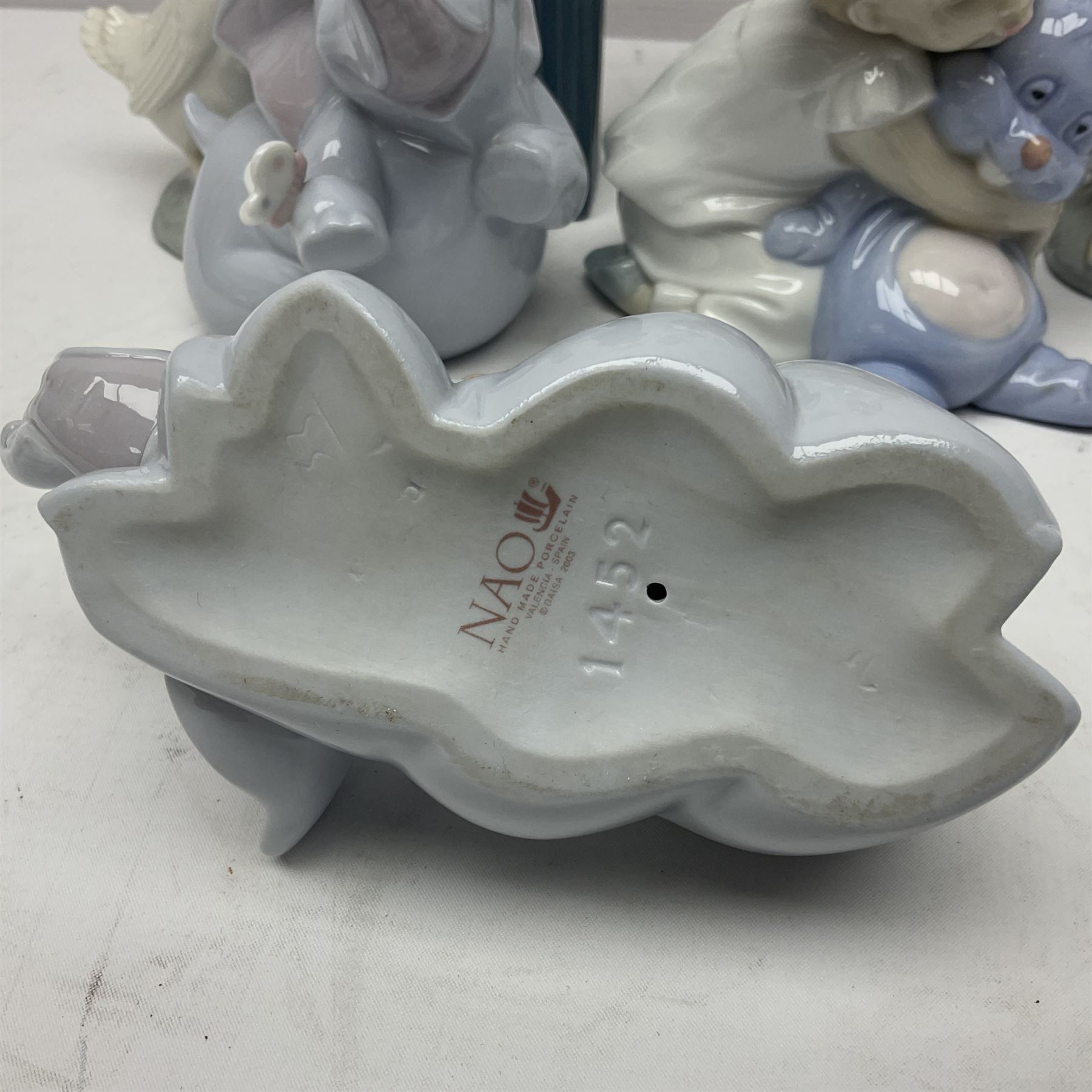 Two Lladro figures, Over the Threshold no 5282 and Prayful Moment no 5500 together with five Nao figures