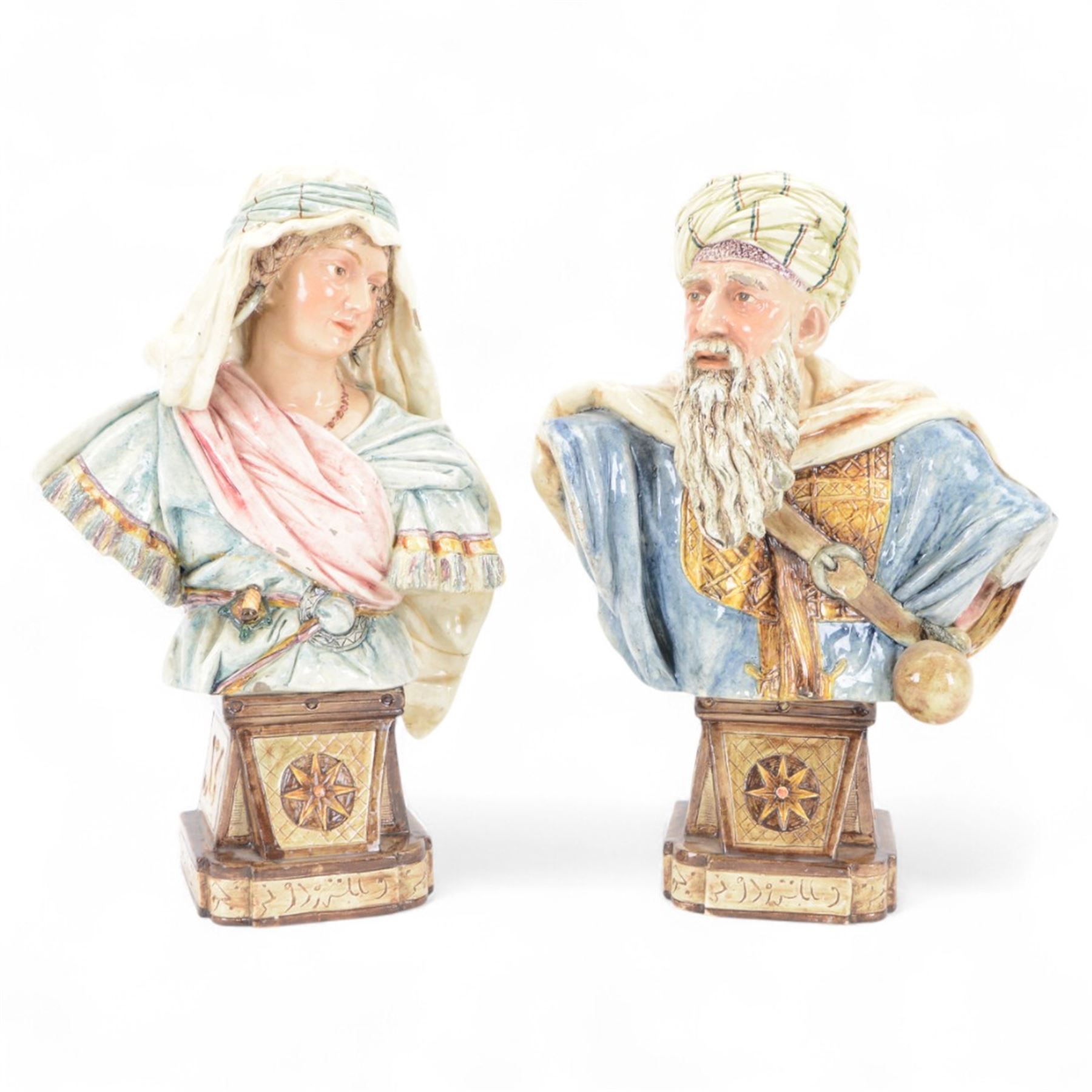 Pair of 19th century German majolica busts, modelled after biblical figures, as a male and female figure in Eastern dress, upon a plinth detailed with script, impressed marks verso 'Gesetz Geschützt' , H37cm