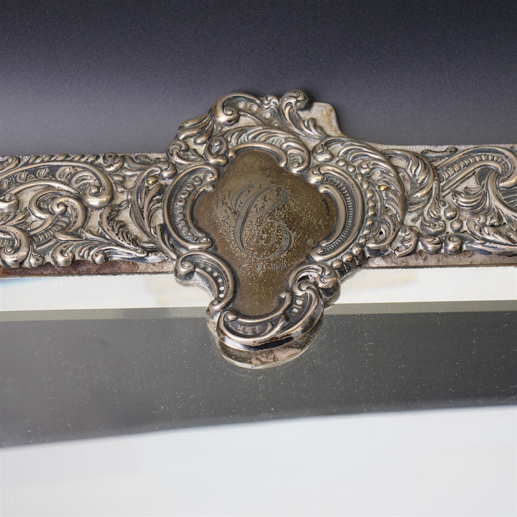 Late Victorian silver mounted dressing table mirror, the frame decorated with scrolls and oval cartouche initialled 'C', bevelled plate on an easel stand 57cm x 38cm London 1899 Maker Charles Henry Dumenil 