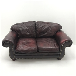  Three seat sofa upholstered in studded oxblood leather, arched back, scrolled arms, turned supports (W230cm) and matching two seat sofa (W177cm) (2)  
