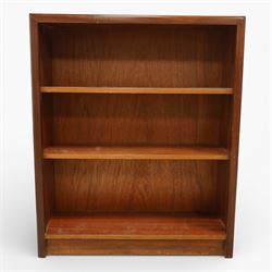 Mid 20th century teak bookcase, of rectangular form with plain top above three open shelves and a shaped plinth base