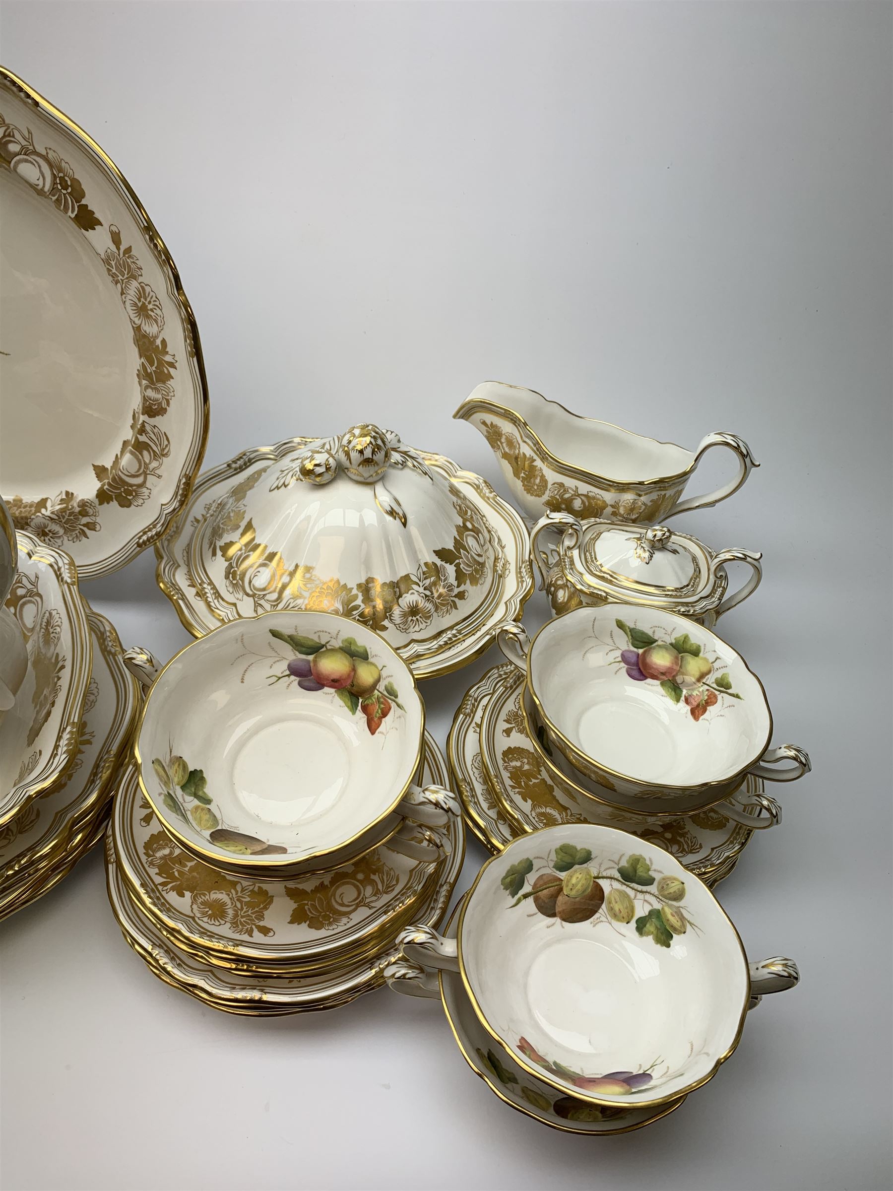 Extensive Spode dinner and tea service, decorated in the Golden Valley pattern, comprising eighteen dinner plates, ten salad plates, ten side plates, ten twin handled soup bowls and ten saucers, ten bowls, two sauce boats and two stands, two square serving dishes, smaller oval serving dish, two tureens and covers, two large oval serving platters, one smaller example, teapot, coffee pot, milk jug, twin handled lidded sucrier, and ten teacups and ten saucers, with red printed marks beneath 