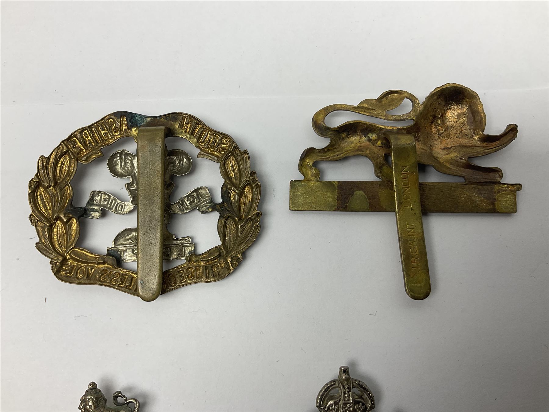 Twenty cap badges including Hertfordshire, Royal Sussex, Cambridgeshire, Hampshire, Notts and Derby, East Surrey, Herefordshire, South Lancashire, Devonshire, Bedfordshire, Durham Light Infantry etc (20)