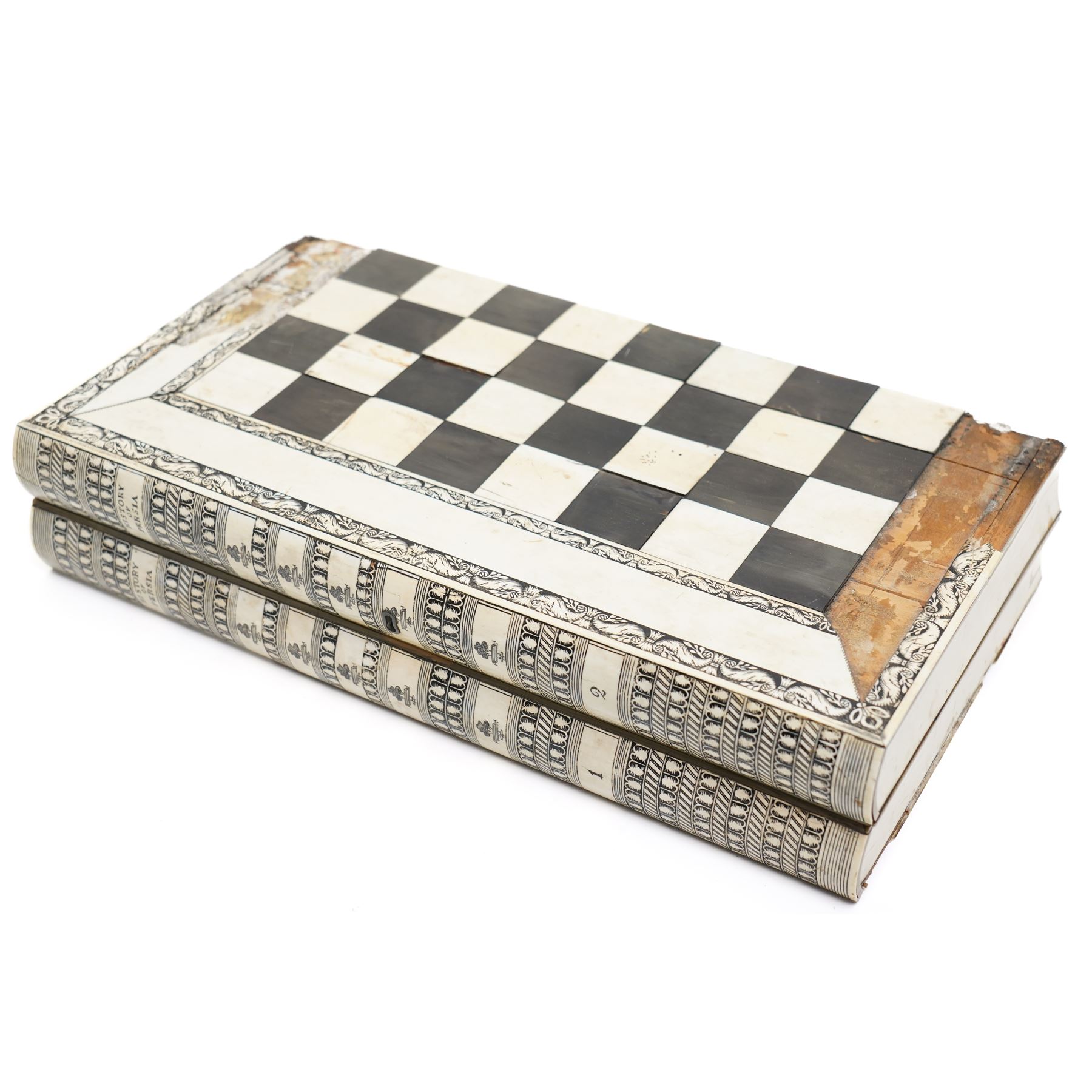 Mid-19th-century Anglo Indian Vizagapatam ivory, sandlewood, and horn veneered backgammon/chess board, circa 1860, rectangular games box the borders engraved with a stylized scrolling leaf decoration and spine engraved History of Persia the interior inlaid for backgammon, with three internal sandalwood boxes with covers, containing 16 ivory pieces and 16 horn pieces, comprising, kings and queens with pierced crowns on baluster carved shafts; bishops with carved mitres; knights represented by horses’ heads; and rooks as towers with imbricated decoration.

This item has been registered for sale under section 10 of the APHA Ivory Act, submission reference G68PNYA5 


