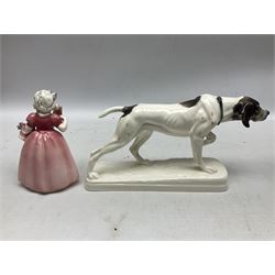 Early 20th century Katzhütte figure of a pointer dog, and figure of a young girl holding basket and fan, both with green cat H house printed mark beneath, dog L25cm