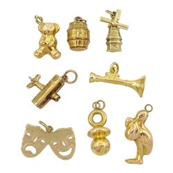 Three 18ct gold charms including teddy bear, stork and baby and dummy, 14ct gold mask charm and four other 9ct gold charms including trumpet and spitfire