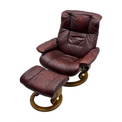 Ekornes Stressless, swivel armchair upholstered in red leather, with matching footstool supported on Oak bases