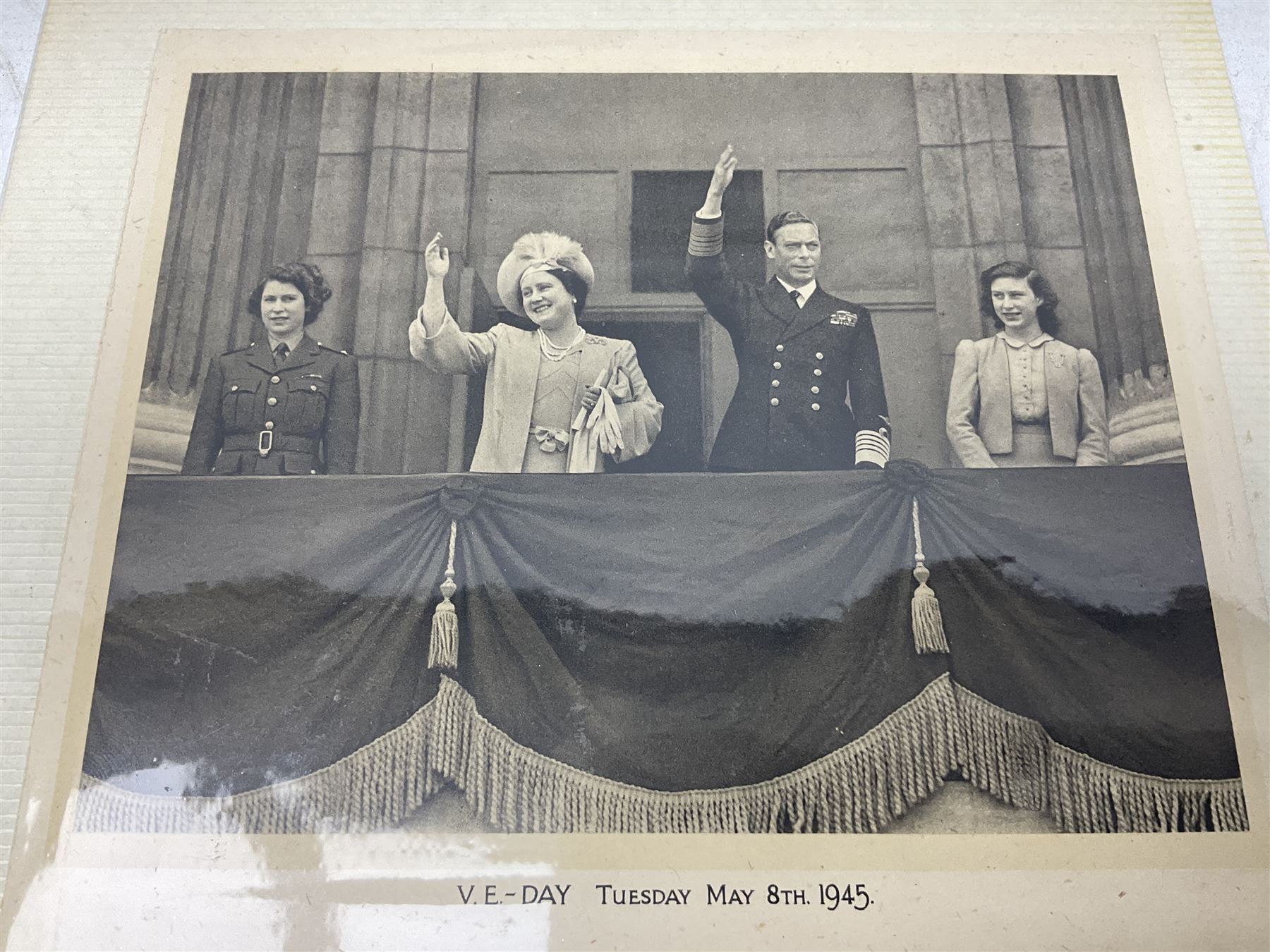 King George VI and Queen Elizabeth - the photograph and signatures only from a 1945 Christmas card depicting The Royal Family waving from the balcony of Buckingham Palace, on V-E Day Tuesday May 8th 1945, signed 'George R.I. Elizabeth R.'