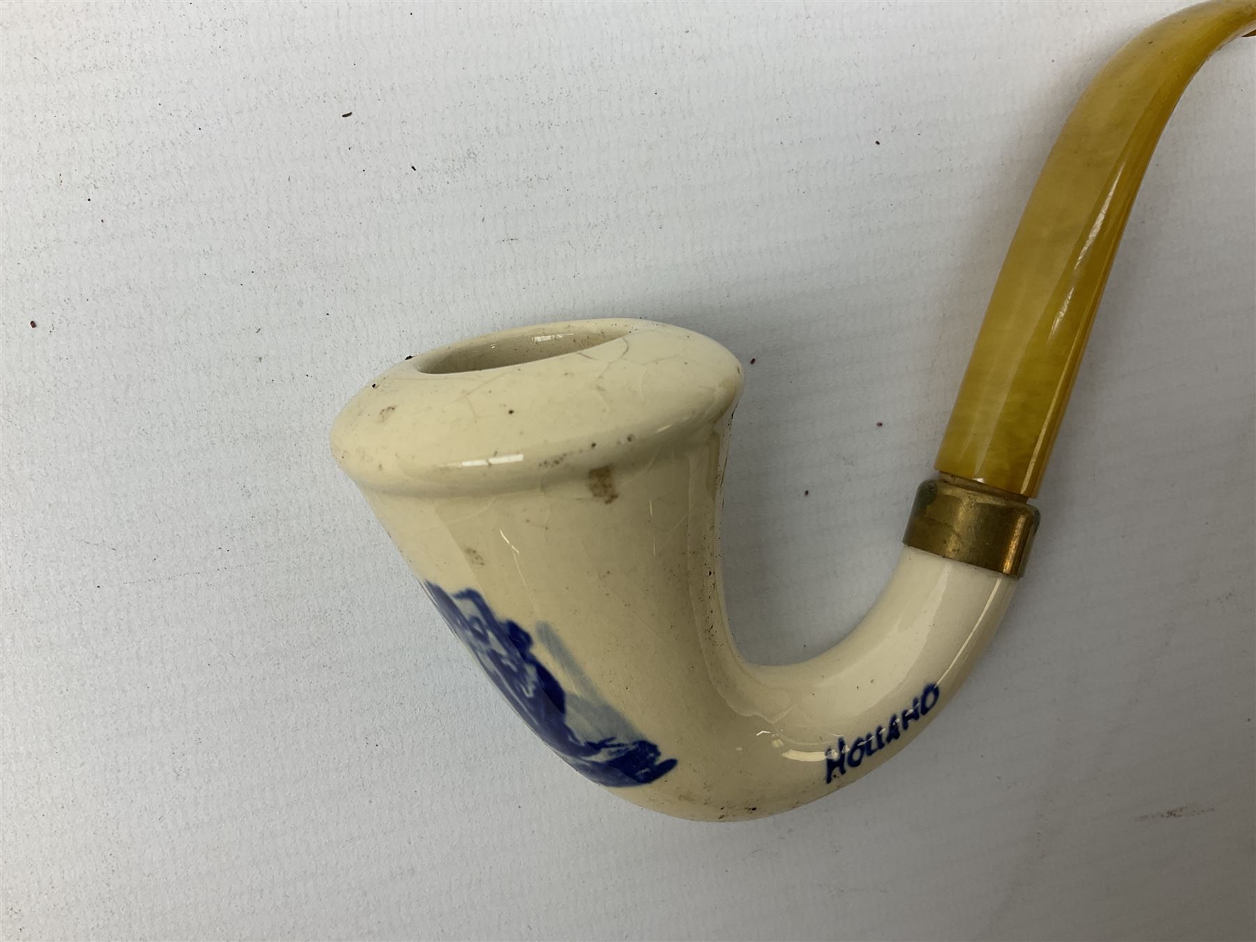 Carved meerschaum and amber pipe with silver mount, the bowl carved as a woman, cased, clay pipe in the form of an acorn, ceramic pipe, five other pipes and a ceramic bottle pourer in the form of a horse  