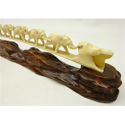  Early 20th century Japanese carved ivory bridge of nine graduating elephants on carved hardwood stand, L40cm and a Meiji period Japanese Okimono carved as a prowling tiger on hardwood base, L13.5cm and three other pre 1947 Indian carved ivory models (5)  