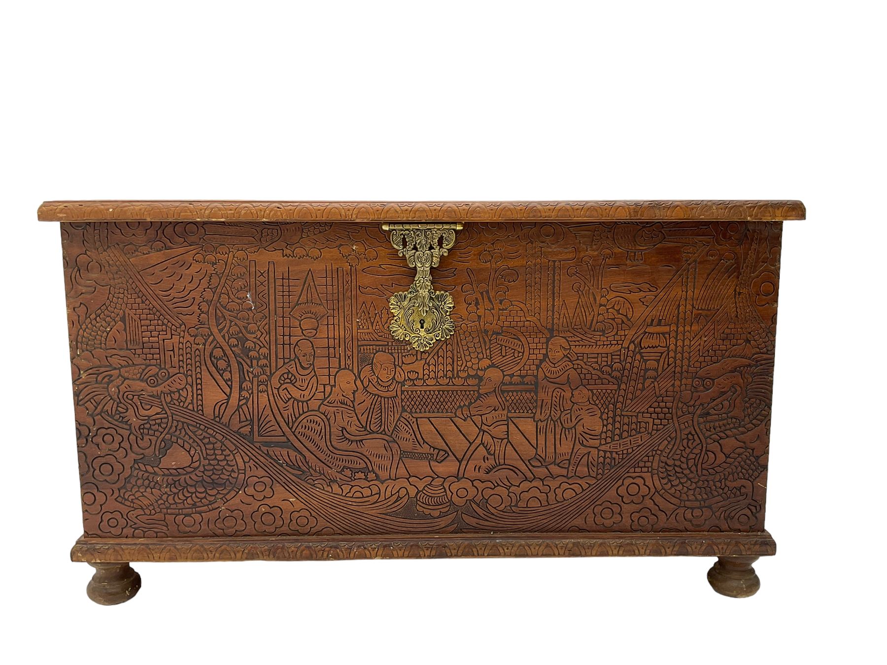 Hong Kong camphor wood chest, rectangular hinged top, carved all over with traditional scenes and dragon boats, on bun feet