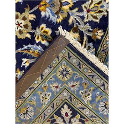 Central Persian Kashan indigo ground carpet, central lighter blue floral medallion surrounded by interlacing leafy branches and stylised plant motifs, the main border decorated with repeating floral motifs and scrolling branches, within guard stripes 