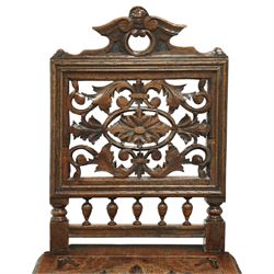 18th century carved oak hall chair, the rectangular pierced back carved with scrolling foliate ornament and central rosette beneath a shaped cresting, the boarded seat carved with stylised foliage, raised on turned legs united by stretchers