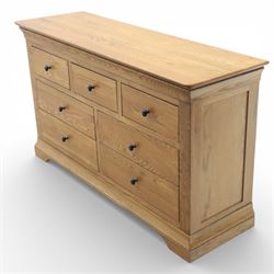 Contemporary oak veneered sideboard, moulded rectangular top above a six drawer arrangement, three over three, each drawer with turned ebonised style knob handle, panelled ends, raised on a shaped plinth base with bracket feet