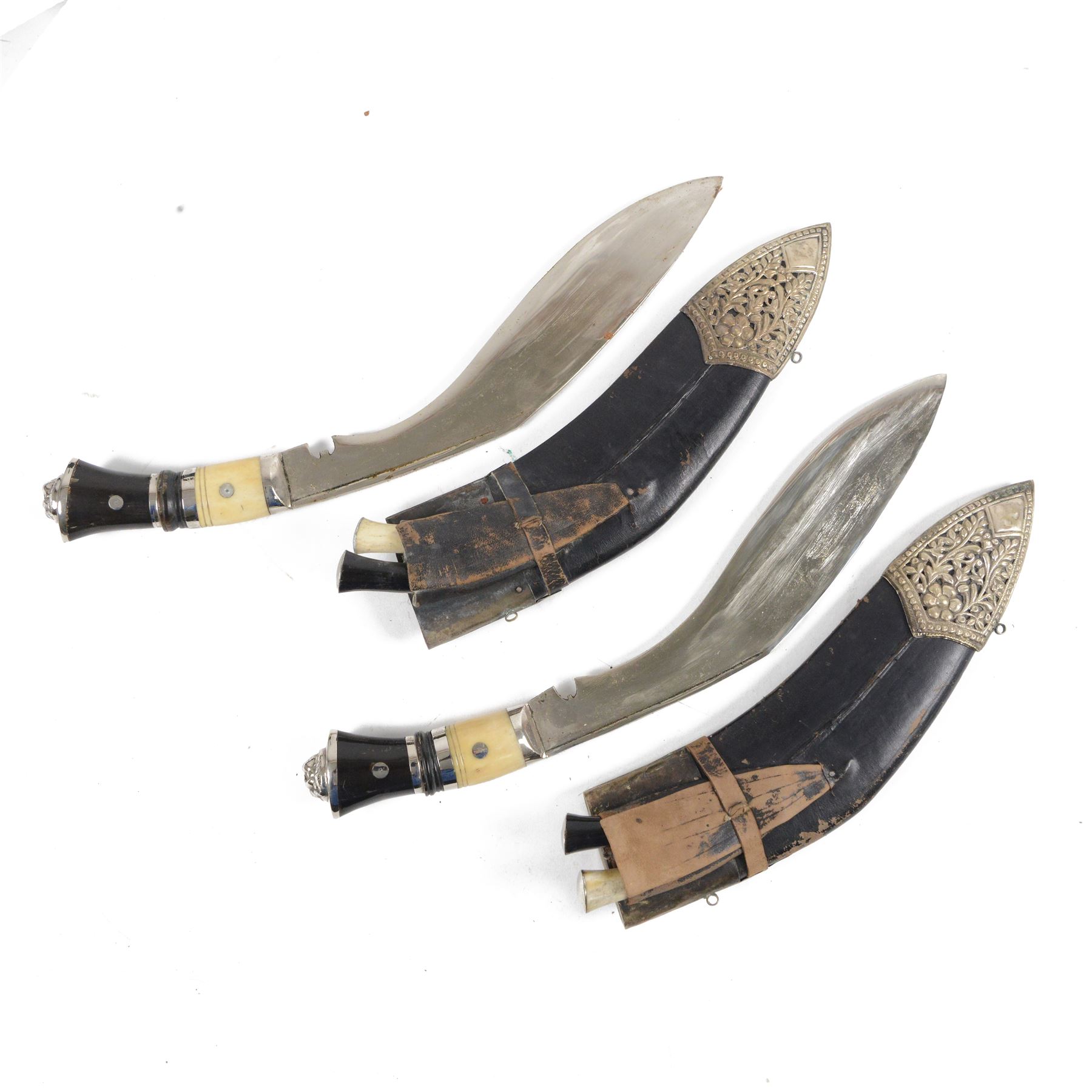 Pair of kukri knives, with with ebonised and bone handles, with two smaller knives, with a leather scabbard with floral silvered decoration, L44cm
