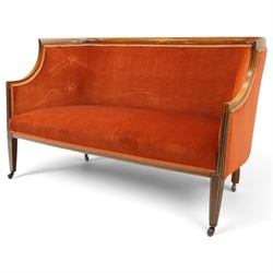 Edwardian inlaid mahogany tub two seater settee, traditional shape with satinwood stringing, upholstered in crimson fabric with sprung seat, on square tapering supports with castors