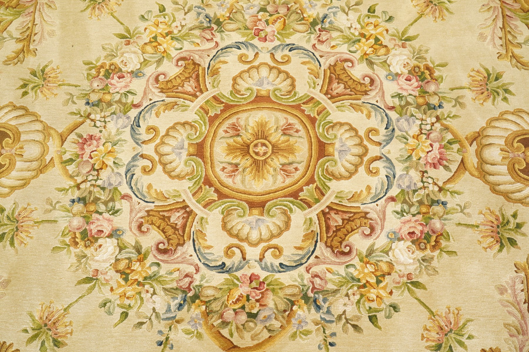 20th century French Aubusson style circular carpet, cream ground of Savonnerie design with scrolling floral and scallop motifs