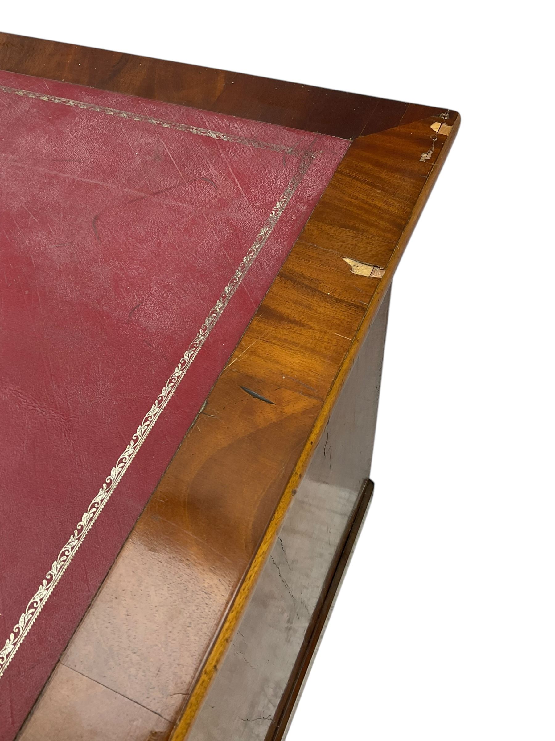 Late 19th to early 20th century walnut pedestal desk, rectangular top inset with red tooled leather writing surface, over a central frieze drawer flanked by two pedestals, each fitted with four graduated drawers with brass escutcheons and drop handles, the whole raised on a plinth base