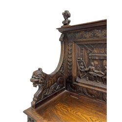 19th century heavily carved oak settle, the moulded upper rail over triangular foliage carved frieze, three Flemish style carved panels depicting tavern scenes, acanthus carved uprights terminating to lion carved arms, hinged box seat, the panelled front carved with lion masks and extending scrolled acanthus leaves, on moulded skirt base