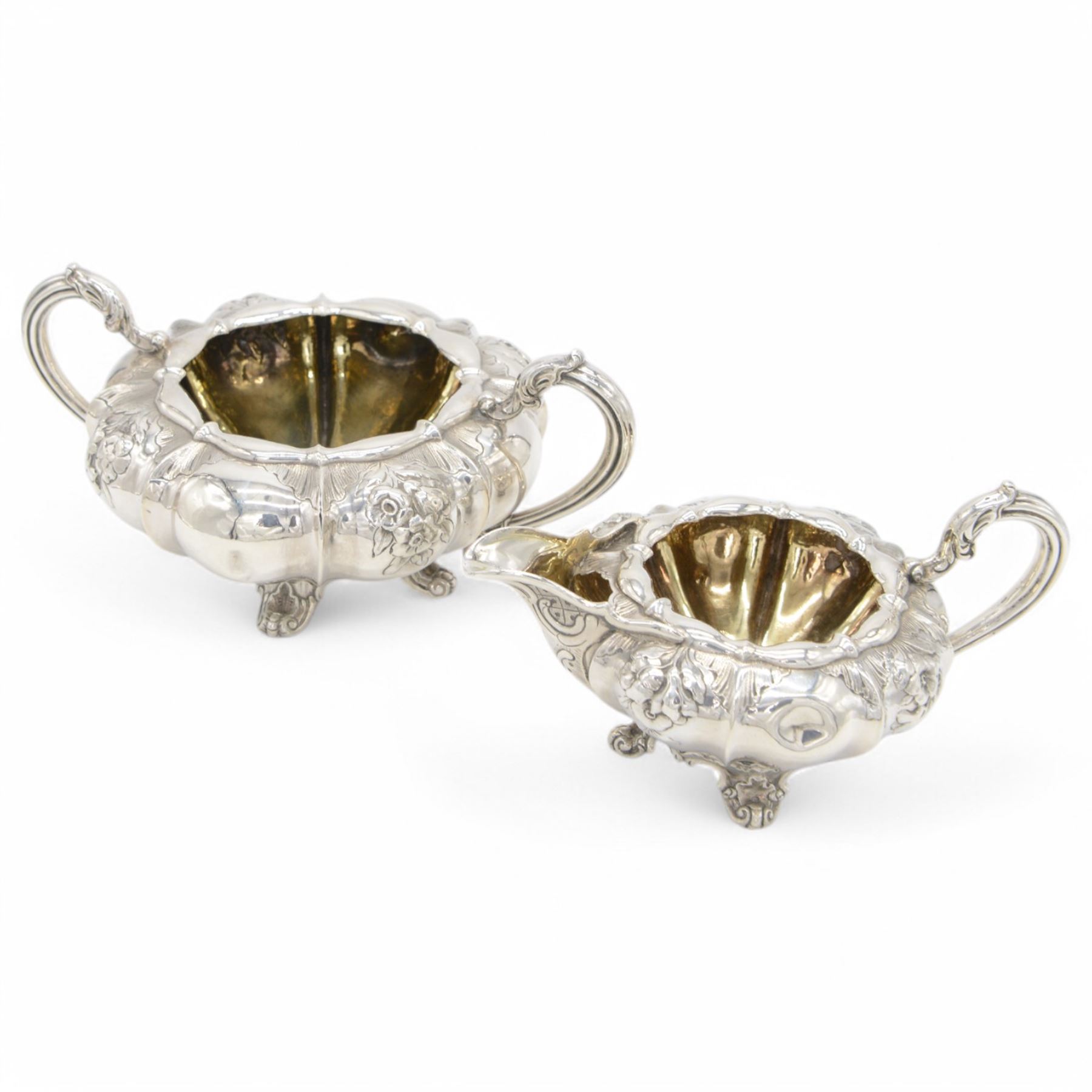 William IV silver twin handled sucrier and milk jug, each of circular bellied form, embossed with floral decoration, upon four pad scroll feet, hallmarked London 1831, maker's marks CE, including handles H10cm