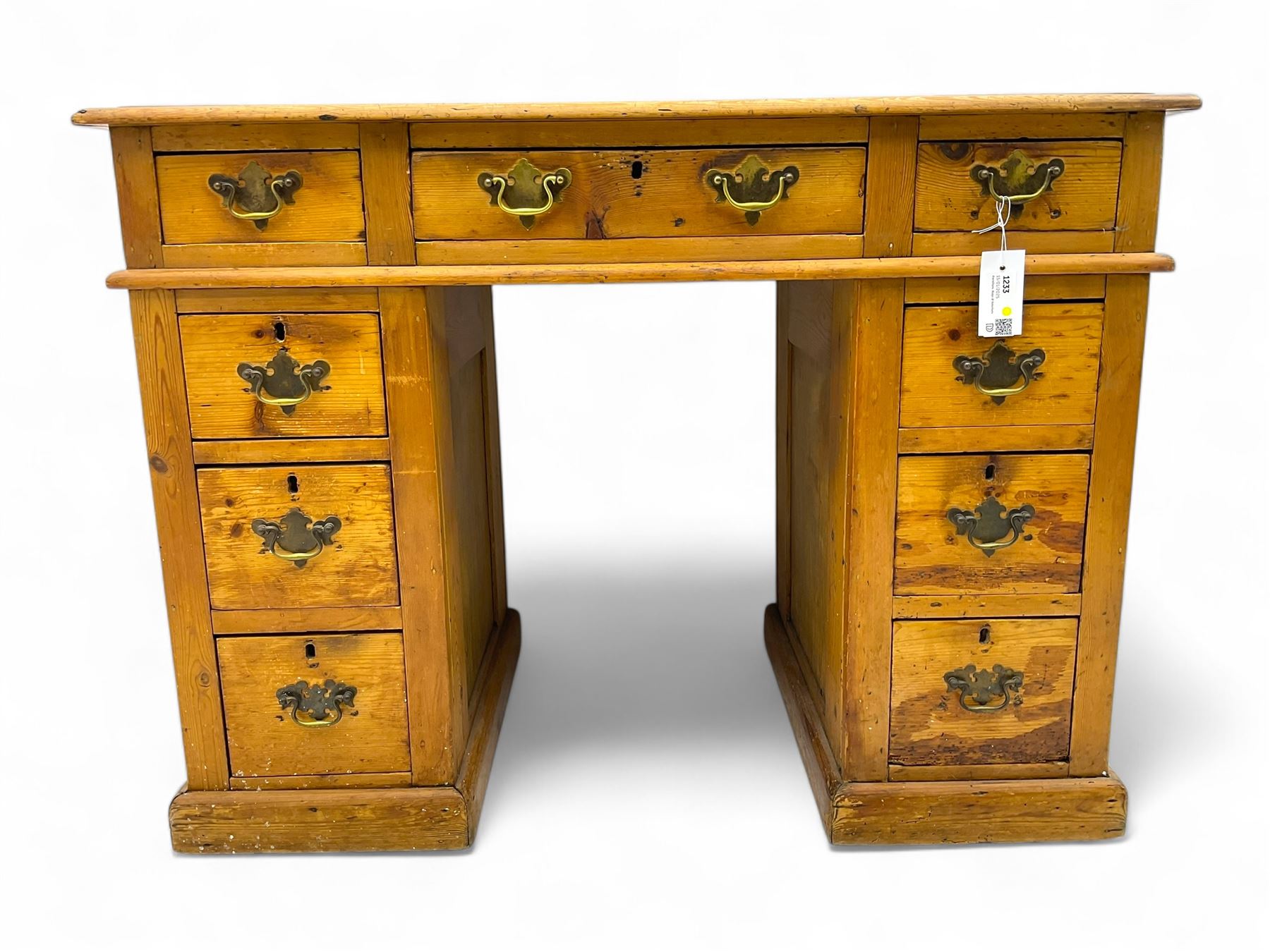 Rustic pine twin pedestal desk, rectangular green leather inset top above a central frieze drawer flanked by two short drawers, each pedestal featuring three graduated drawers, raised on a plinth base