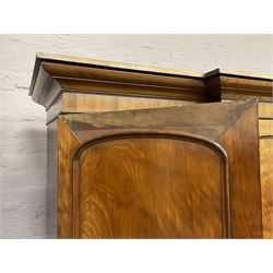 19th century figured mahogany quadruple breakfront press wardrobe, projecting cornice with banded frieze over arch panelled doors, the interior fitted with three sliding trays over two short and three long graduating drawers with recessed brass handles, flanked by two hanging cupboards with hooks