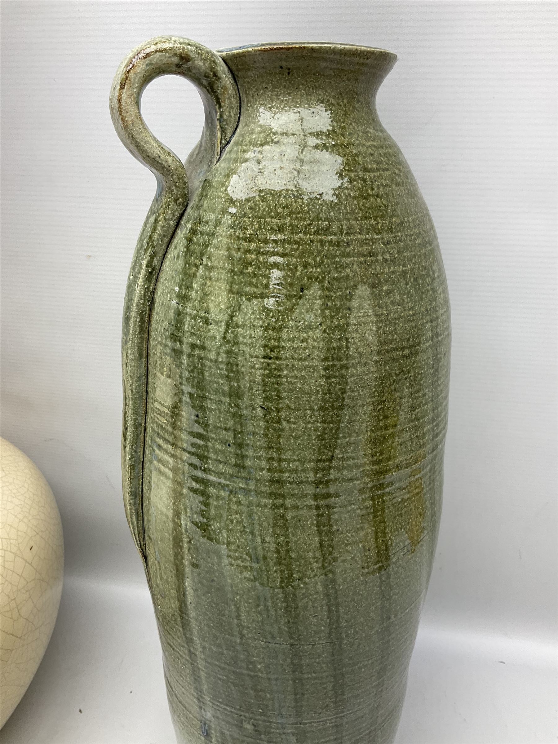 Large cream crackle glaze table lamp, together with a tall studio pottery vase in green with single loop handle, with impressed makers mark, H49cm