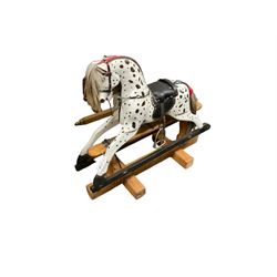 Small black and white painted rocking horse, fitted with saddle and stirrups, on painted trestle base with turned pillars 