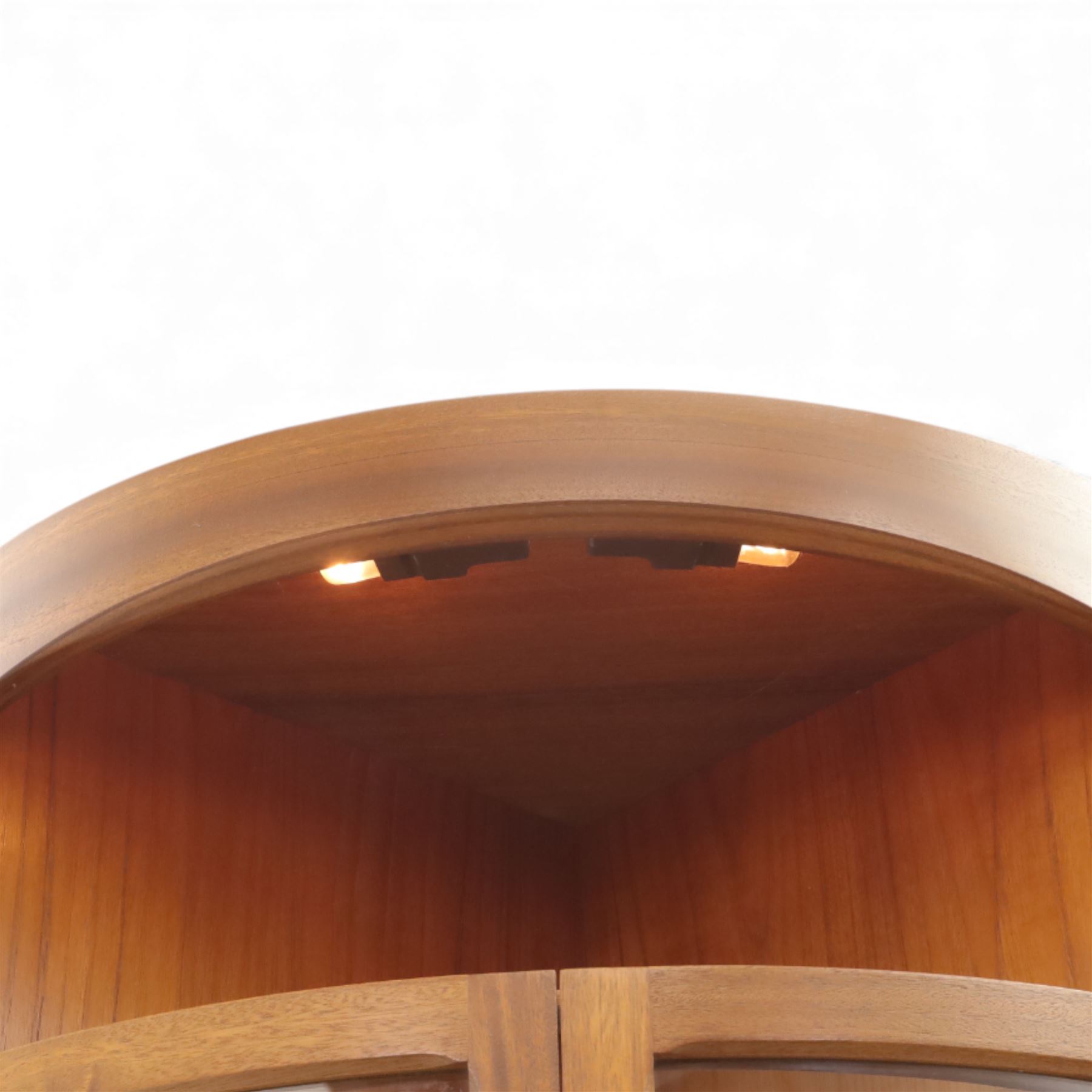 Nathan for Parker Knoll - corner cabinet, the upper section enclosed by two curved glazed doors with glass shelves, over a shaped base fitted with a single frieze drawer and panelled twin cupboard doors