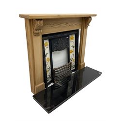 Complete fireplace - pine surround with ornate cast iron inset with Art Nouveau style floral tiles, granite hearth, brass fender and optional gas fire fitting