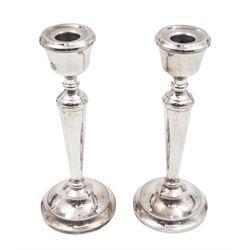 Pair of modern silver mounted candle sticks, with taping stems and upon beaded circular filled bases, hallmarked P H Vogel & Co, Birmingham 1975, H21cm