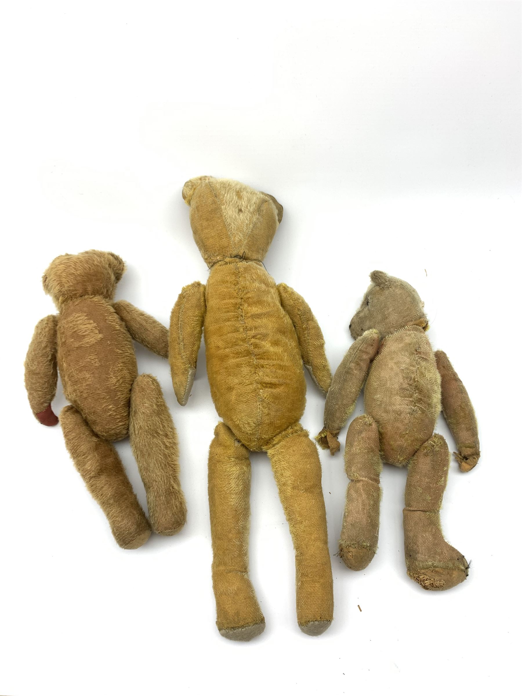 Early 20th century American wood wool filled short bristle mohair long bodied teddy bear with swivel jointed head, boot button eyes and vertically stitched nose and mouth and jointed limbs H23