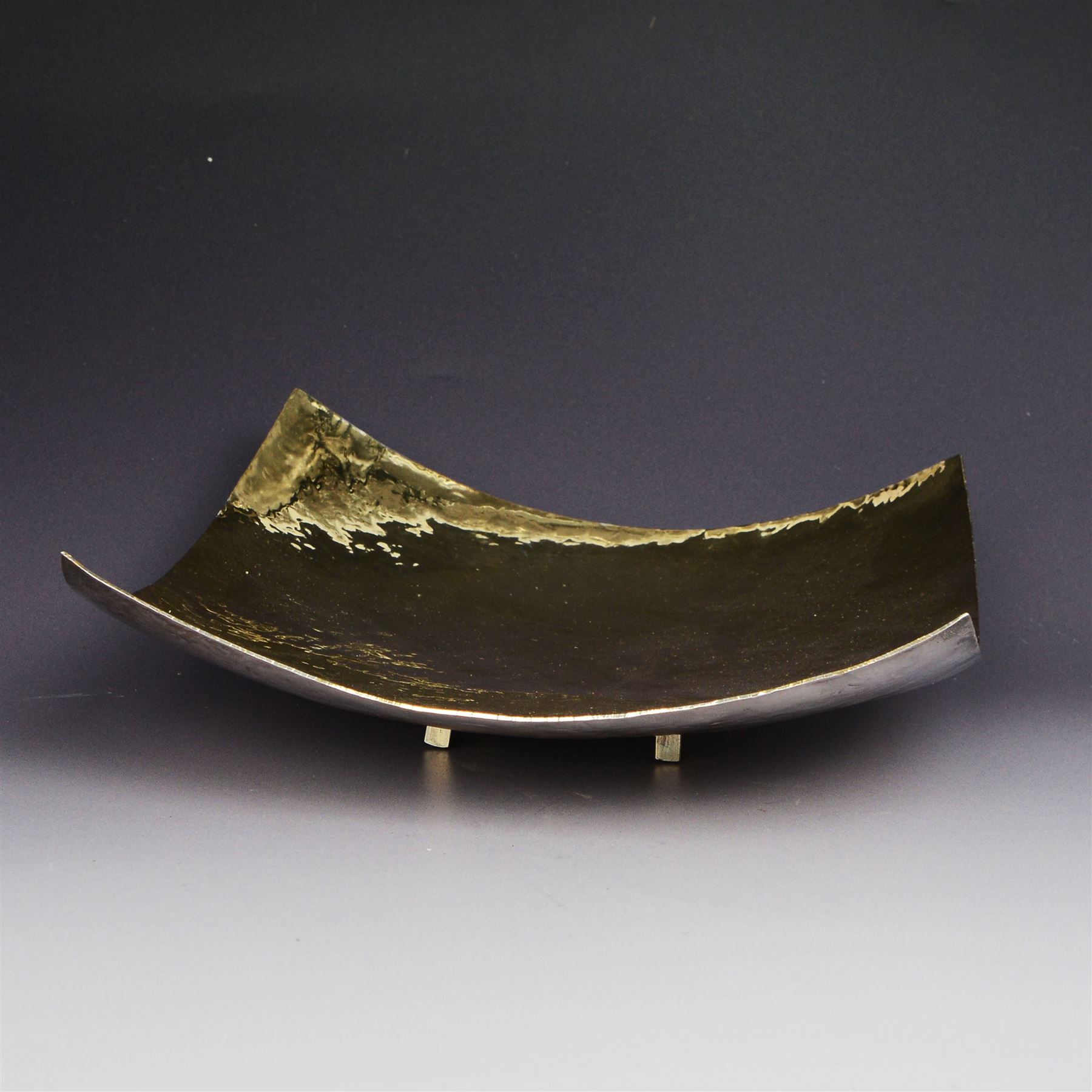 Modern silver bowl, of square concave form, with gilt interior and gilt spiral decoration to underside, with planished decoration throughout, upon four column feet, hallmarked Jonathan Braganza, London 2013, H5cm, W18cm