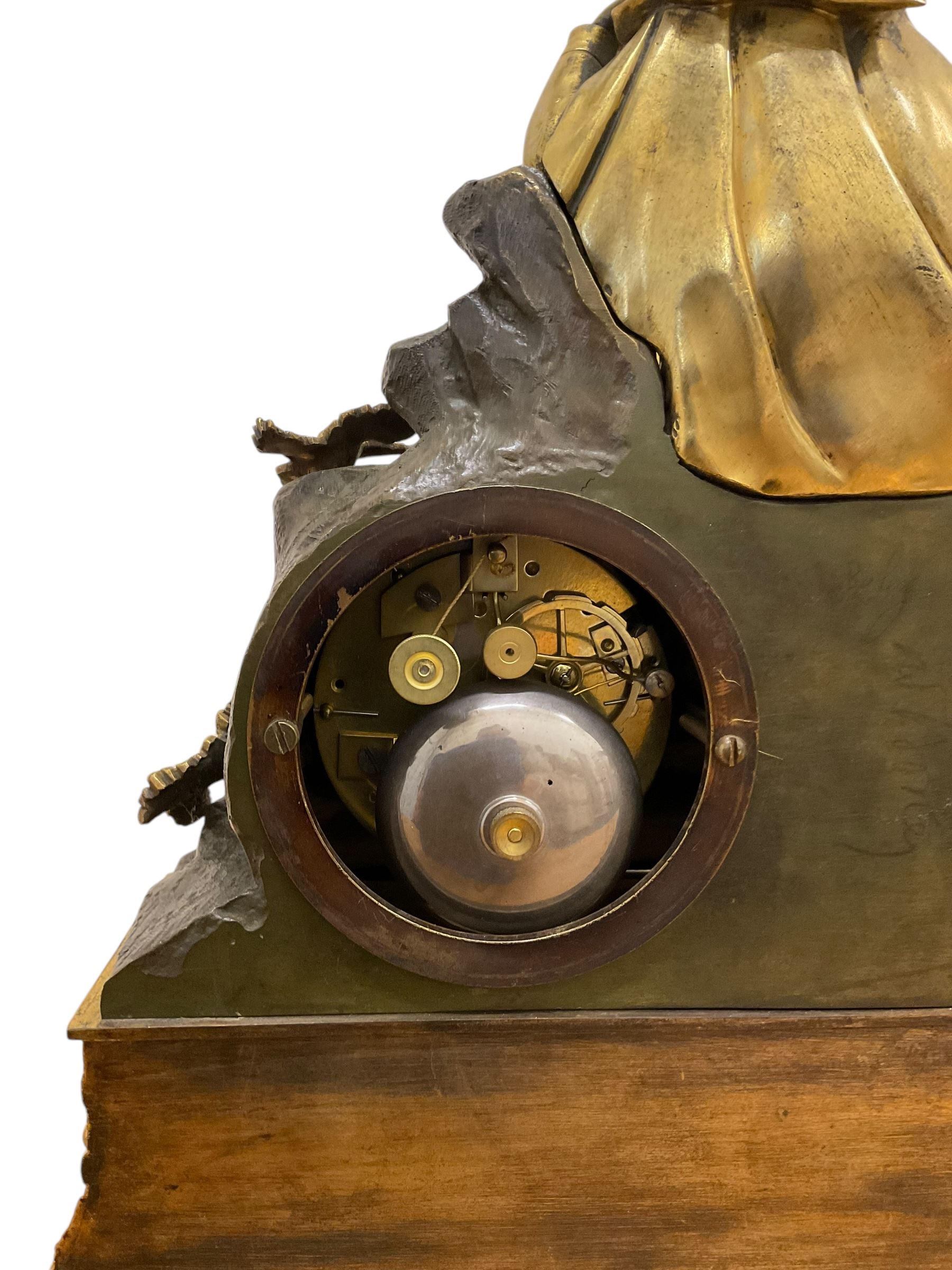 French-Louis XVIII  8-day mantle clock c1820, on a rectangular gilt metal base incorporating repeating cast leaf decoration on a pierced apron and bracket feet, surmounted with a cast brass figure depicting a reclining lady in 18th century dress, Parisian drum movement with a silk suspension and unglazed silvered dial, with Roman numerals and steel moon hands, dial pinned to a countwheel striking movement, sounding the hours and half-hours on a bell. With pendulum and key.
