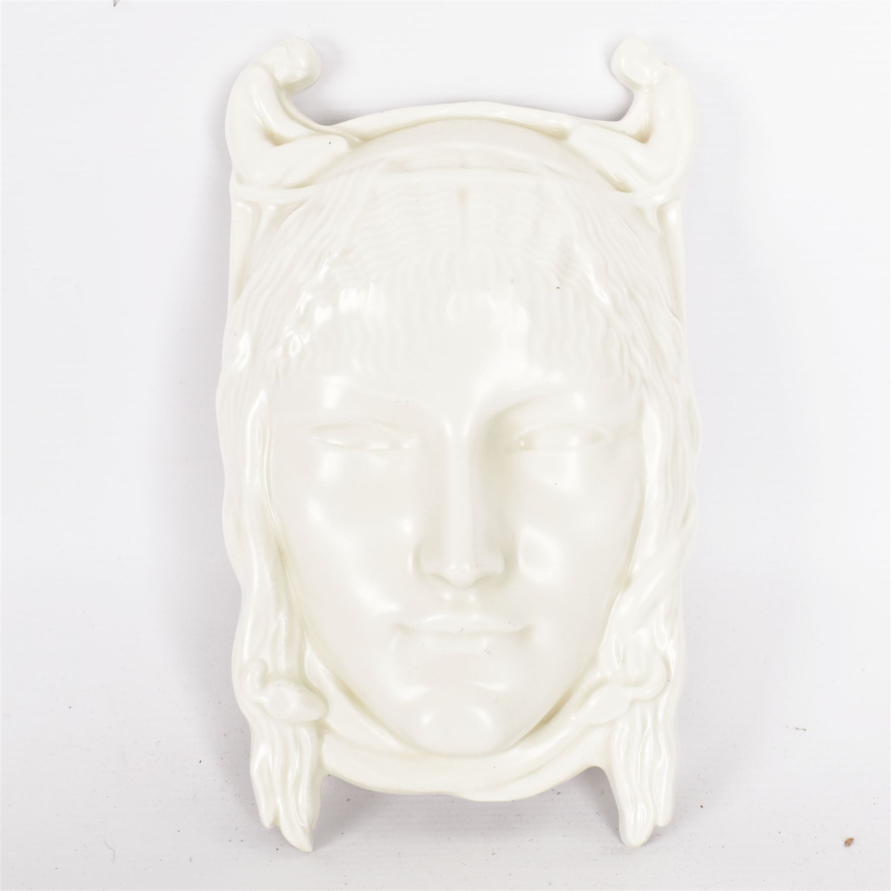 Richard Garbe, A.R.A. for Doulton & Co. 'Fate' ceramic wall mask, modelled as a female head, her hair entwinned with serpents, flanked by two miniature kneeling nudes, covered in a matt ivory glaze, painted signature and marks, limited edition no. 15/100, impressed 848, 41034, L27.5cm x W15.5cm 