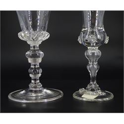19th century drinking glass, the trumpet bowl with oblique trailing upon a multi annulated knopped stem and folded circular foot, H18.5cm, together with a further 19th century drinking glass, the bell shaped bowl with prunt detail, upon stem with conjoined baluster and folded circular foot with conforming prunt detail, H16cm