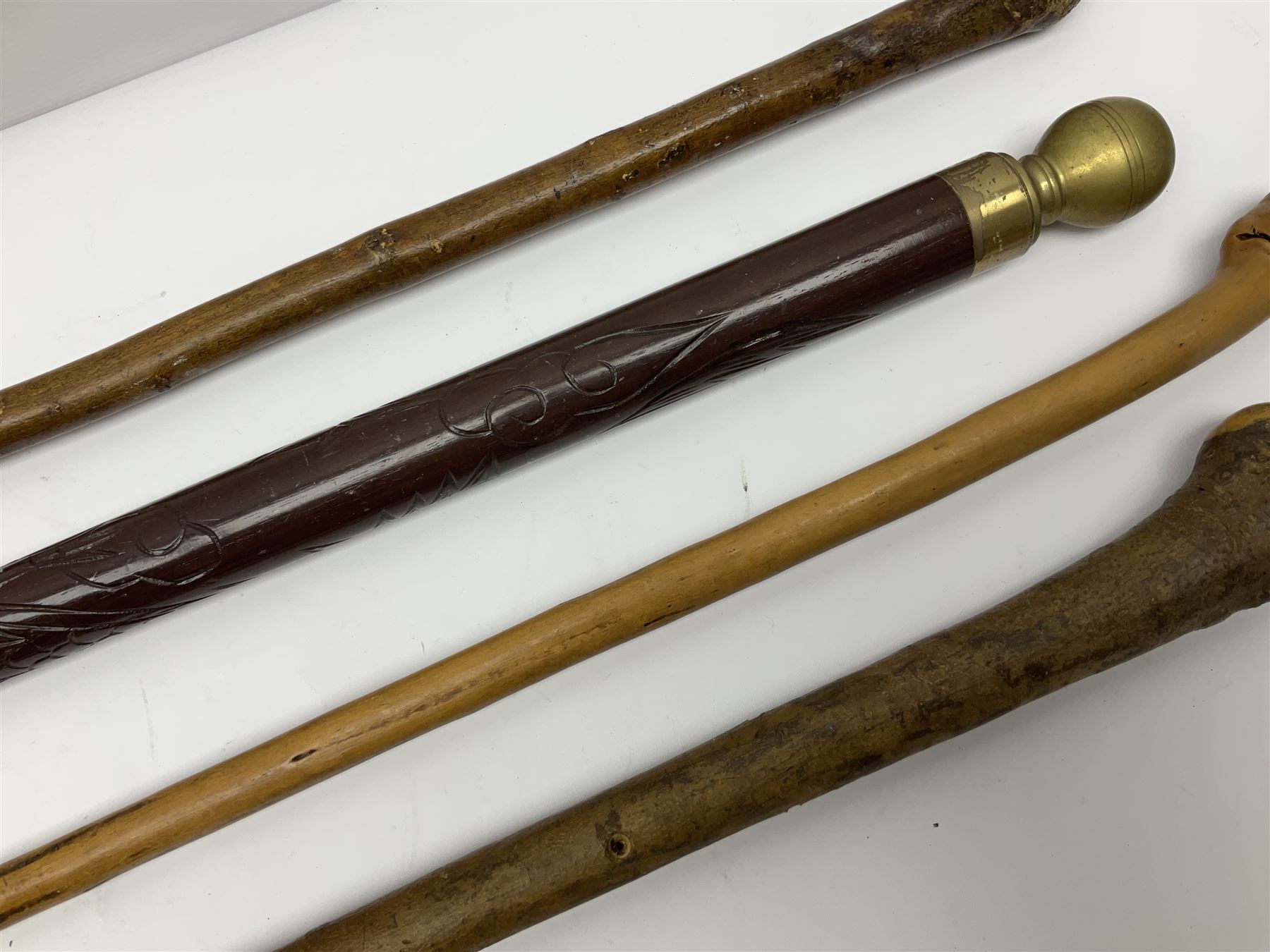 Four wooden walking canes, including a carved mahogany snooker cue example, tallest H86cm