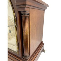 Jungans - German 8-day early 20th century chiming mantle clock in a mahogany case, with a break arch top and carrying handle, dial flanked with reeded pilasters, raised on brass bracket feet, sheet dial with a silvered chapter ring, subsidiary fast/slow and strike/silent dials, three train movement chiming the quarters on four gong rods and the hours on a coiled gong.
