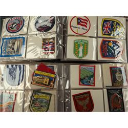 Large collection of souvenir cloth badges and vinyl stickers, mostly contained within albums