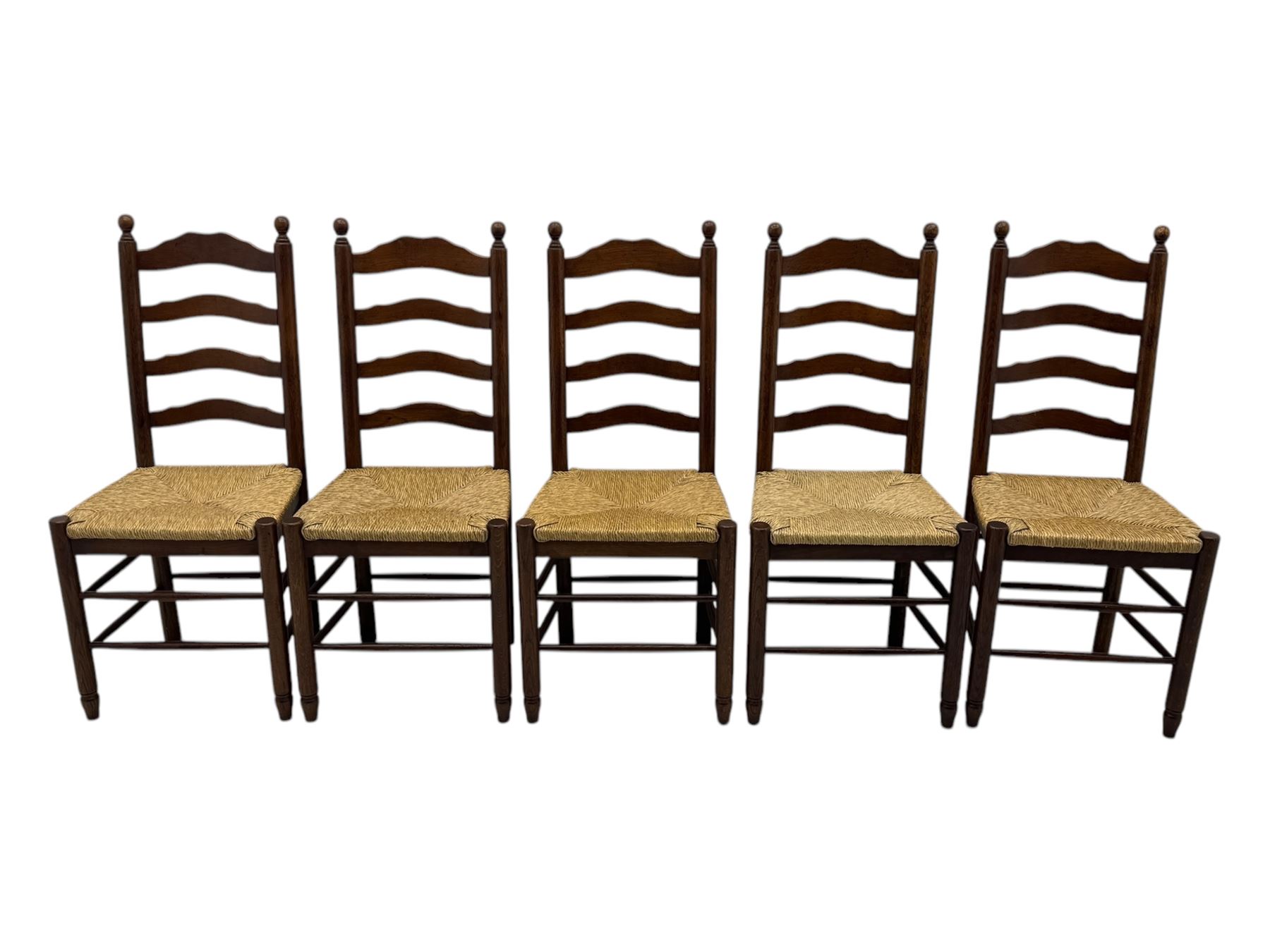 Set of ten 18th century design oak ladder back dining chairs, shaped cresting rail over four horizontal splats, rush seat raised on turned supports united by double stretchers